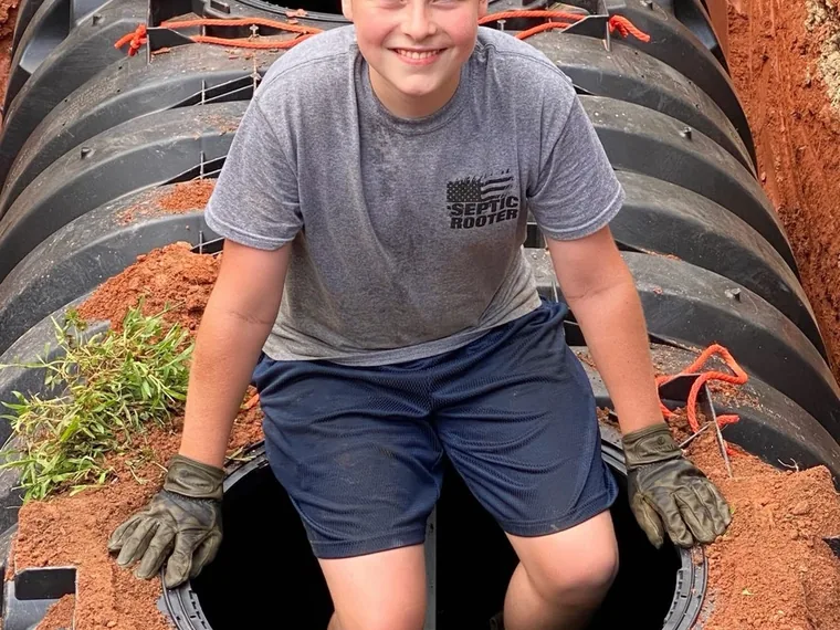 SepticRooter mini-excavator and crew installing a septic system